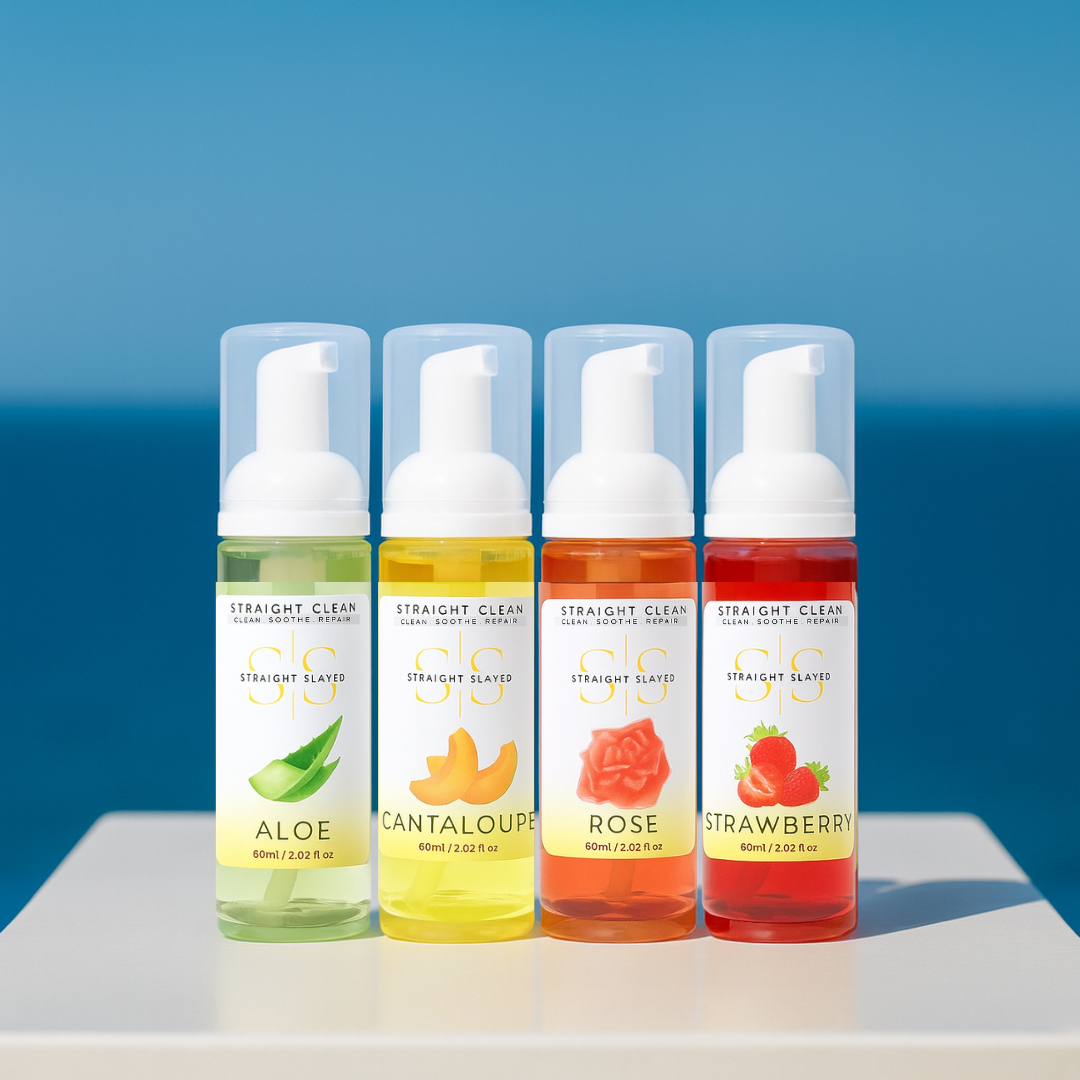 Four bottles of Straight Clean Skincare with different fruit flavors against a blue sky.